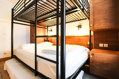 two bunk beds in a bedroom with wooden walls at Newly redecorated 2-bed ski-in ski-out family apartment in Flaine