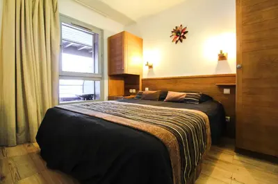 a bedroom with a bed and a window in it at Newly redecorated 2-bed ski-in ski-out family apartment in Flaine