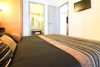 a bedroom with a bed with a television on the wall at Newly redecorated 2-bed ski-in ski-out family apartment in Flaine
