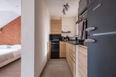 a small kitchen with a bed in a room at L'Appart 52, magnifique duplex en plein coeur de Chamonix-Mont-Blanc in Chamonix-Mont-Blanc