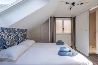 a bedroom with a large white bed with blue towels on it at L'Appart 52, magnifique duplex en plein coeur de Chamonix-Mont-Blanc in Chamonix-Mont-Blanc