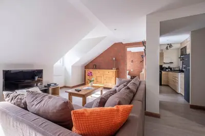 a living room with a couch and a table at L'Appart 52, magnifique duplex en plein coeur de Chamonix-Mont-Blanc in Chamonix-Mont-Blanc