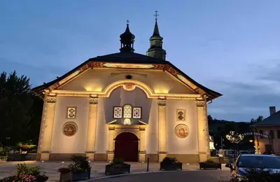 a large white church with a clock tower on top at Alpenrose in Saint-Gervais-les-Bains
