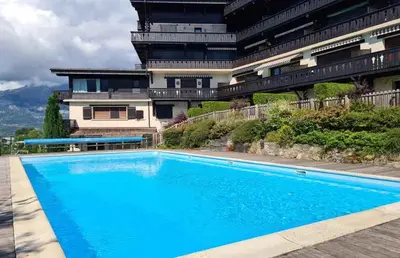 a large blue swimming pool in front of a building at Alpenrose in Saint-Gervais-les-Bains