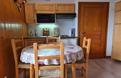 a kitchen with a table and chairs in a kitchen at Alpenrose in Saint-Gervais-les-Bains