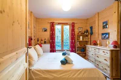 a bedroom with a bed and a window at Comme un chalet, appartement à la montagne in Saint-Gervais-les-Bains