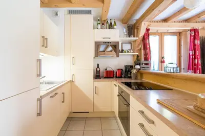 a kitchen with white cabinets and a counter top at Comme un chalet, appartement à la montagne in Saint-Gervais-les-Bains