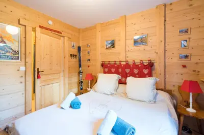 a bedroom with a large bed in a wooden room at Comme un chalet, appartement à la montagne in Saint-Gervais-les-Bains