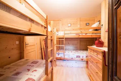 a log cabin bedroom with two bunk beds at Comme un chalet, appartement à la montagne in Saint-Gervais-les-Bains
