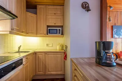 a kitchen with wooden cabinets and a blender on a counter at Apartment With Balcony Close To The Ski Slopes in Chamonix-Mont-Blanc