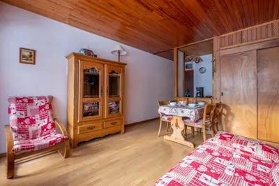 a bedroom with a bed and a table and a cabinet at Apartment With Balcony Close To The Ski Slopes in Chamonix-Mont-Blanc
