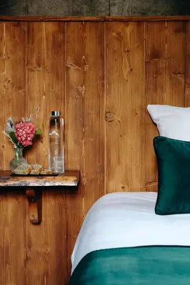a bed with green and white sheets and pillows at Auberge des Gorges - Restaurant Gastronomique & Chambres in Servoz