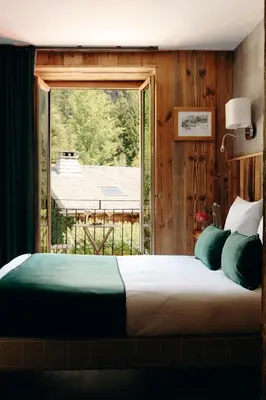 a bedroom with a bed and a wooden wall at Auberge des Gorges - Restaurant Gastronomique & Chambres in Servoz