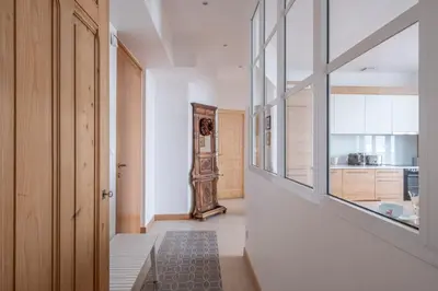 a hallway with a large window and a kitchen at Nice Apt With Balcony In Chamomix in Chamonix-Mont-Blanc