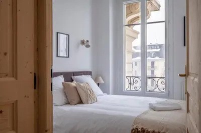 a bedroom with a white bed and a window at Nice Apt With Balcony In Chamomix in Chamonix-Mont-Blanc