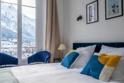 a bedroom with a bed and a window with mountains at Nice Apt With Balcony In Chamomix in Chamonix-Mont-Blanc