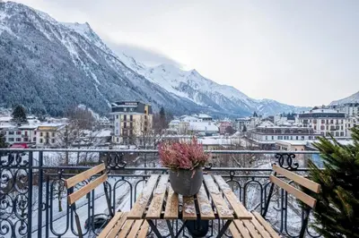 a wooden table with a potted plant on a balcony at Nice Apt With Balcony In Chamomix in Chamonix-Mont-Blanc