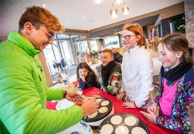 a group of people standing around a table with food at Résidence Club MMV Samoens Village in Samoëns