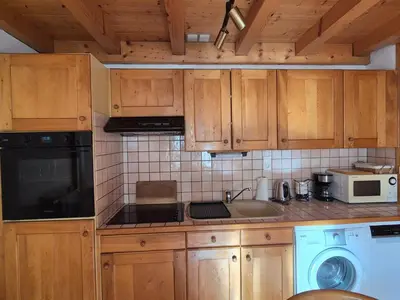 a kitchen with wooden cabinets and a sink and a dishwasher at Appartement sud chaleureux, proche centre et ski, WIFI - FR-1-624-14 in Samoëns
