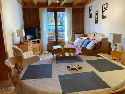 a living room with a table and a bed at Appartement sud chaleureux, proche centre et ski, WIFI - FR-1-624-14 in Samoëns