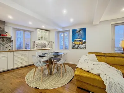 a kitchen and living room with a table and chairs at Chamonix Hyper centre . terrasse vue mont blanc . parking in Chamonix-Mont-Blanc