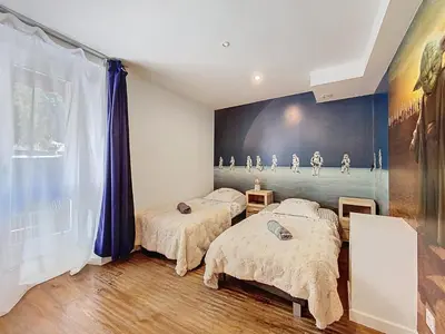 two beds in a room with a painting on the wall at Chamonix Hyper centre . terrasse vue mont blanc . parking in Chamonix-Mont-Blanc