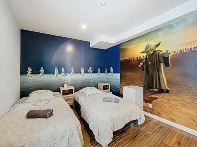 a bedroom with two beds and a painting on the wall at Chamonix Hyper centre . terrasse vue mont blanc . parking in Chamonix-Mont-Blanc