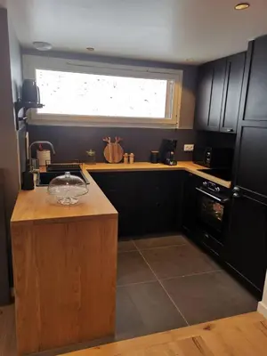 a kitchen with black cabinets and a window at Kaban' des neiges in Saint-Gervais-les-Bains