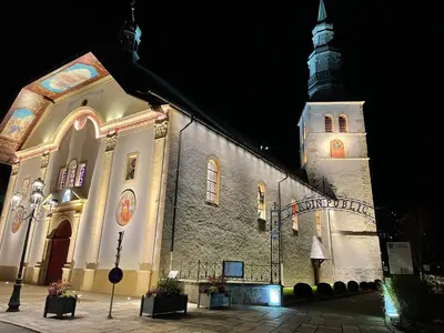 a church with a clock tower at night at Kaban' des neiges in Saint-Gervais-les-Bains