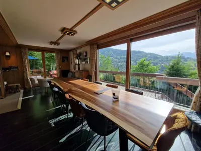 a large wooden table in a room with a large window at Chalet du Vernay in Saint-Gervais-les-Bains