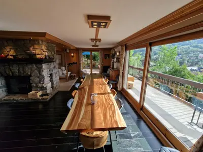 a long wooden table in a room with a fireplace at Chalet du Vernay in Saint-Gervais-les-Bains