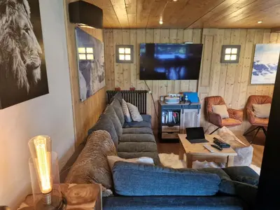 a living room with a couch and a tv at Chalet du Vernay in Saint-Gervais-les-Bains
