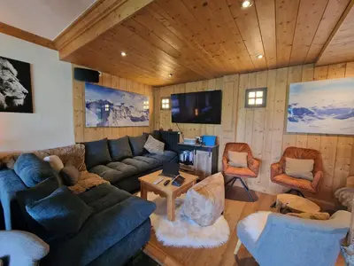 a living room with a couch and chairs and a tv at Chalet du Vernay in Saint-Gervais-les-Bains