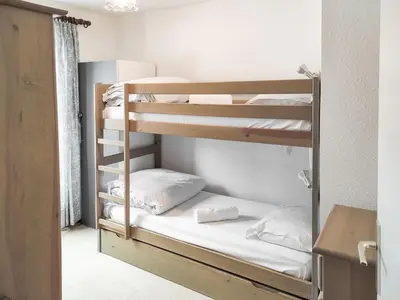 a room with two bunk beds with white pillows at Chemin du Sapi - Private Garden - Center of Cham - MontBlanc Views in Chamonix-Mont-Blanc