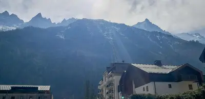 a building with a mountain in the background at Chemin du Sapi - Private Garden - Center of Cham - MontBlanc Views in Chamonix-Mont-Blanc