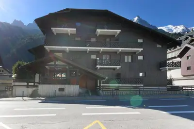 a building with a parking lot in front of it at Chemin du Sapi - Private Garden - Center of Cham - MontBlanc Views in Chamonix-Mont-Blanc