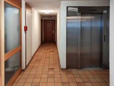 an empty hallway with an elevator in a building at Chemin du Sapi - Private Garden - Center of Cham - MontBlanc Views in Chamonix-Mont-Blanc