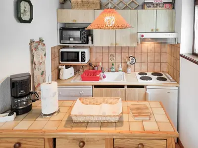 a small kitchen with a table and a sink at Chemin du Sapi - Private Garden - Center of Cham - MontBlanc Views in Chamonix-Mont-Blanc