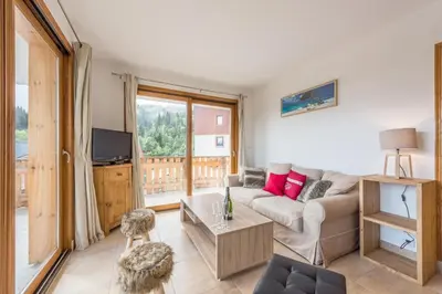 a bedroom with two bunk beds and a window at L'Eden Ski aux Pieds in Morillon