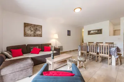 a living room with two white couches and pink pillows at L'Eden Ski aux Pieds in Morillon