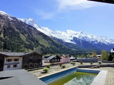 a resort with a pool in front of a mountain at Apartment Le Beau Site by Interhome in Chamonix-Mont-Blanc