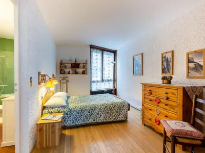 a bedroom with a bed and a dresser and a window at Apartment Le Beau Site by Interhome in Chamonix-Mont-Blanc