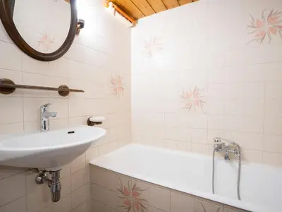 a bathroom with a sink and a tub and a mirror at Apartment Le Prarion by Interhome in Les Houches