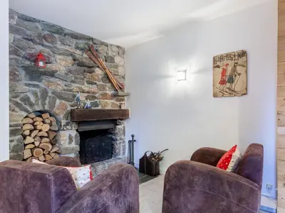 a living room with two chairs and a stone fireplace at Apartment Le Diorama-3 by Interhome in Saint-Gervais-les-Bains