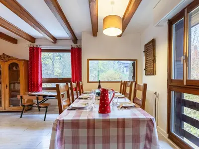 a dining room with a table and chairs and windows at Apartment Le Diorama-3 by Interhome in Saint-Gervais-les-Bains