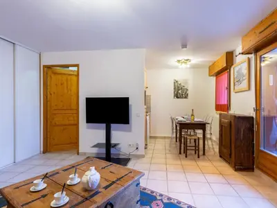 a living room with a table and a tv at Apartment L'Espace Montagne-17 by Interhome in Chamonix-Mont-Blanc