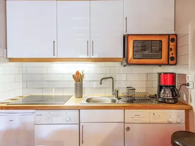 a kitchen with white cabinets and an orange microwave at Apartment les Huskies-6 by Interhome in Saint-Gervais-les-Bains