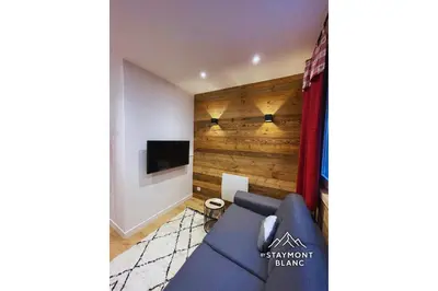 a living room with a blue couch and a tv at Charmant 2 pièces cosy au cœur de Saint-Gervais in Saint-Gervais-les-Bains