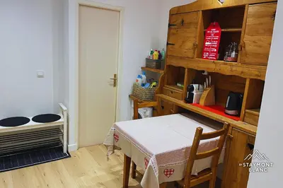 a kitchen with a table and a room with a table and a shelf at Charmant 2 pièces cosy au cœur de Saint-Gervais in Saint-Gervais-les-Bains
