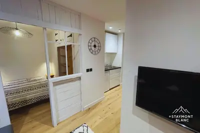 a kitchen with a sliding door and a clock on a wall at Charmant 2 pièces cosy au cœur de Saint-Gervais in Saint-Gervais-les-Bains